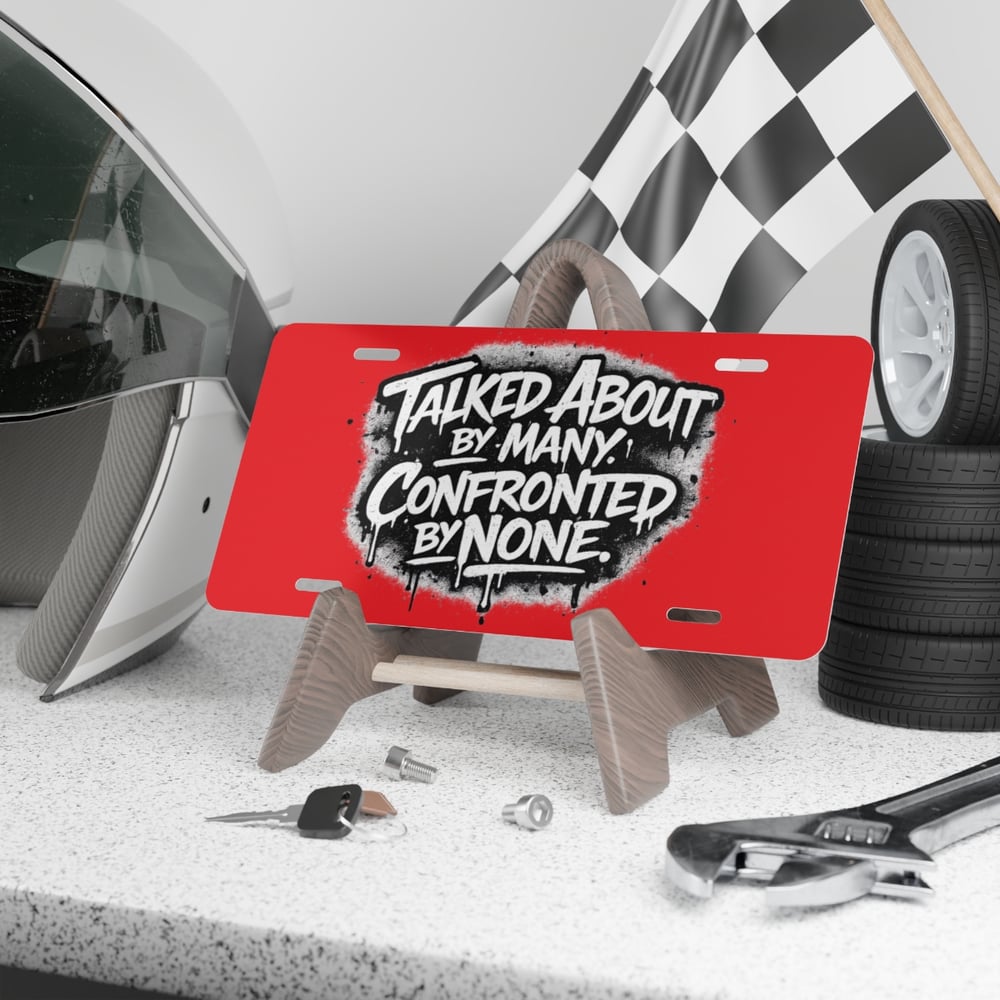 Image of Vanity Plate - 'Talked About by Many, Confronted by None' Red License Plate