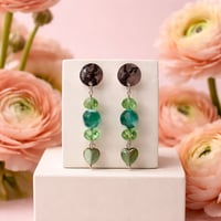 SILVER AND GREEN EARRINGS WITH A GREEN HEART DANGLES.