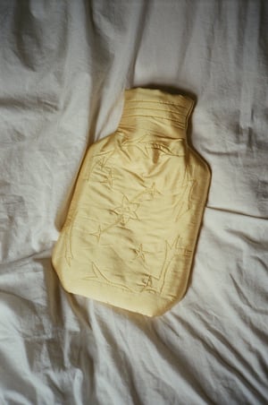 Image of Silk covered hot water bottle, butter with stars