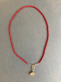 Image 1 of Brass Averting Eye on a coral strand 
