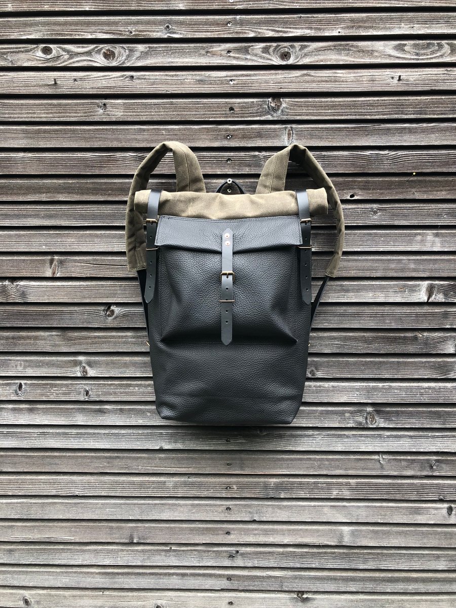 Image of Black leather backpack with waxed canvas roll to close top and leather front pocket