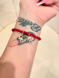 Image 1 of autism red stretchy bracelet with gold laminated charms 
