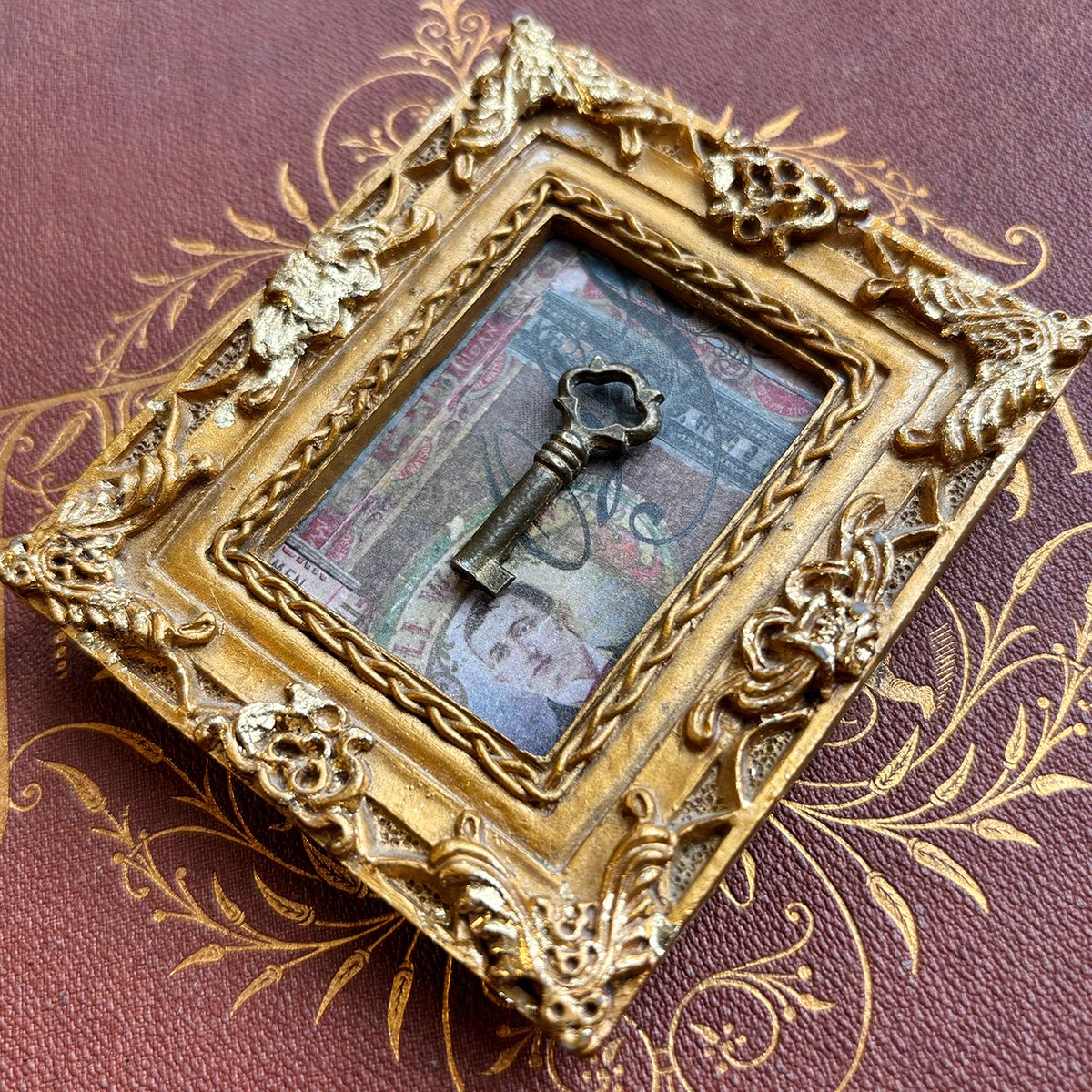 Tiny Brass Barrel Key in Ornate Gold Vintage frame