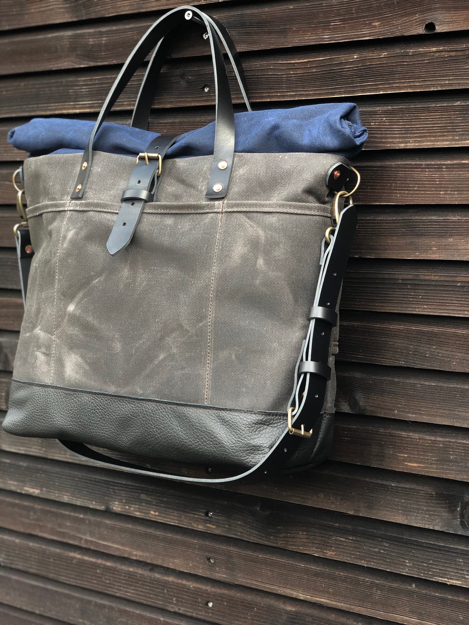 Image of Waxed canvas roll to close top tote bag with luggage handle attachment leather handles and shoul