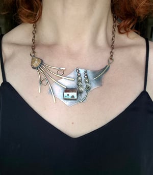 Necklace with a house under a mallow flower