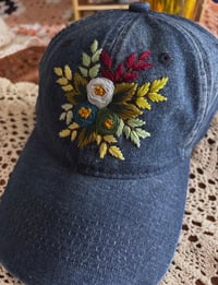 Image 2 of Blue and green hand embroidered flowers on an adjustable dark blue jean fabric hat