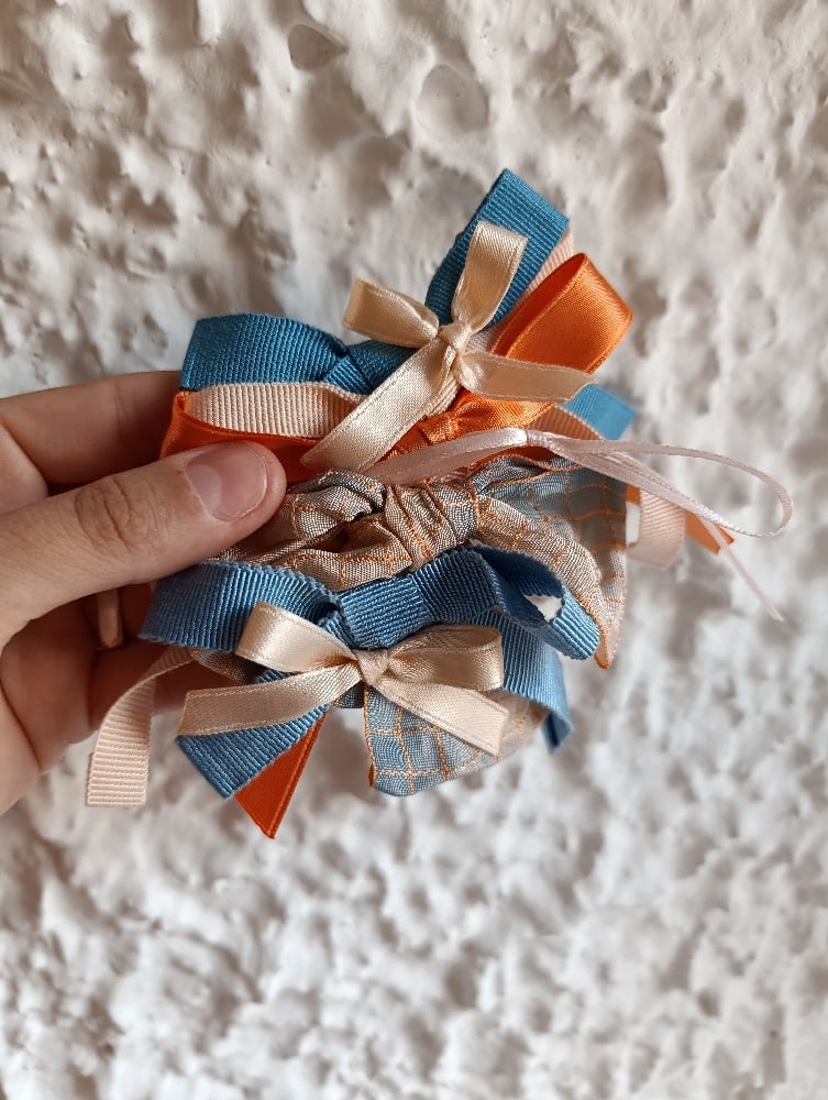 Image of Fermaglio fiocchi misti cipria/albicocca/azzurro 