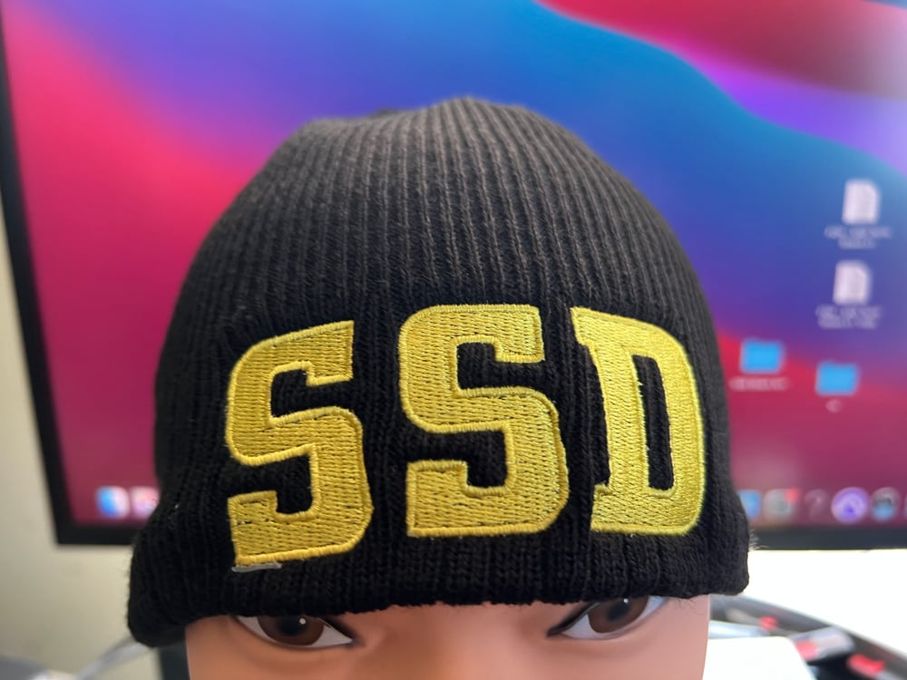 Black New Era Knit beanie hat with Solid Yellow SSD logo