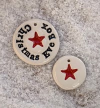 Image 1 of Christmas Eve Box tag and a red star tag