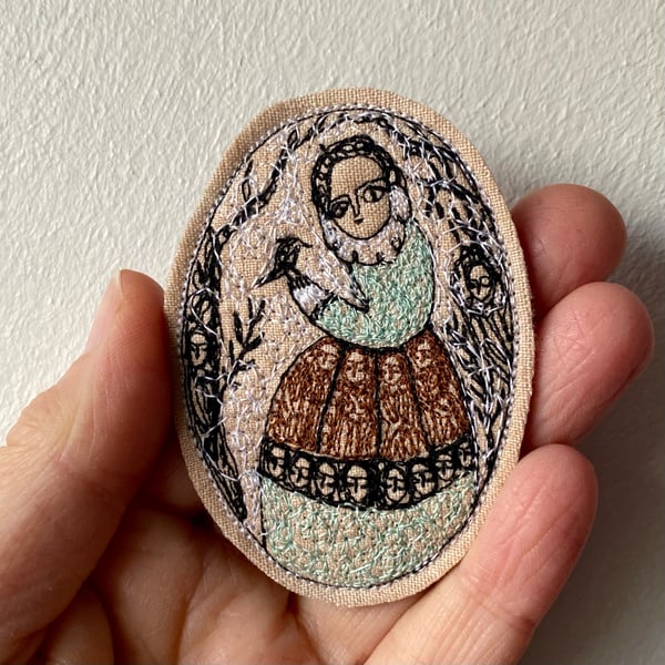 Image of Folk figure in winter with bird in hand - embroidery portrait 