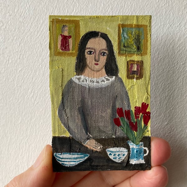 Image of Young woman in grey at a table - tiny painting 