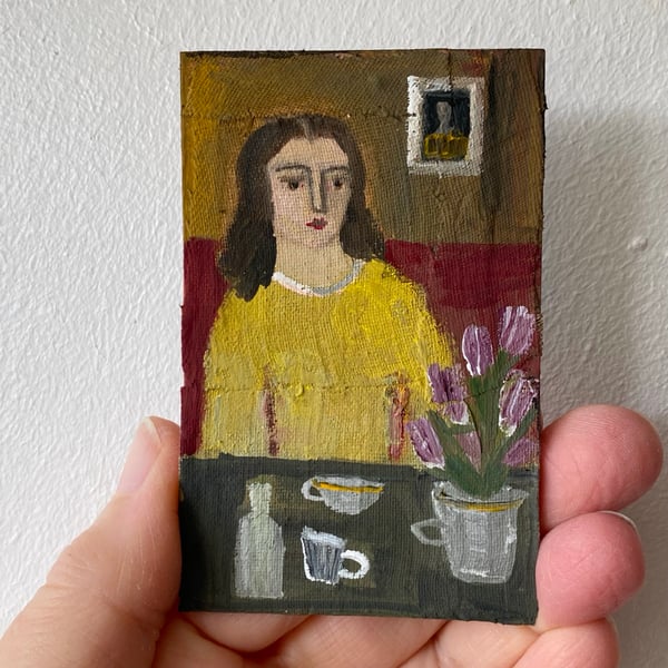 Image of woman in yellow at a table with tulips - tiny painting 