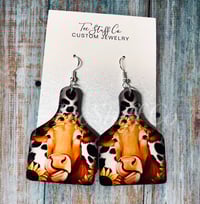 Image 1 of Cow With Sunflower Tag Earrings