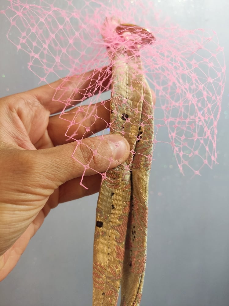 Image of Fermaglio con veletta rosa e code