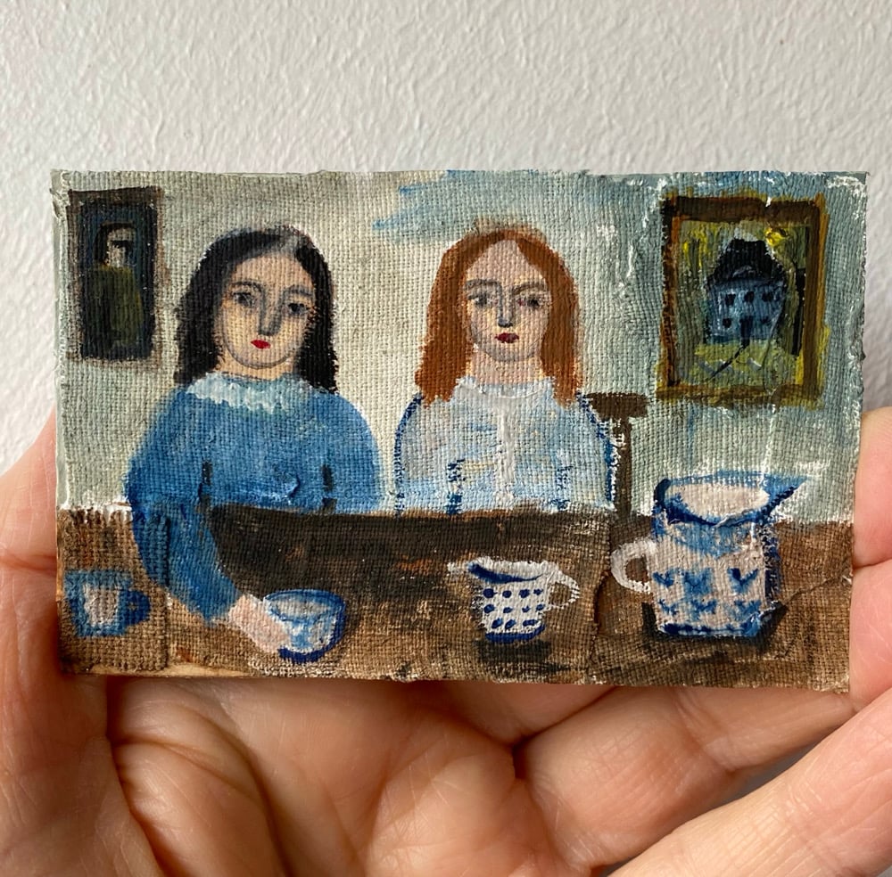 Image of two girls in blue at a table