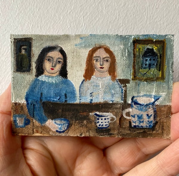 Image of two girls in blue at a table