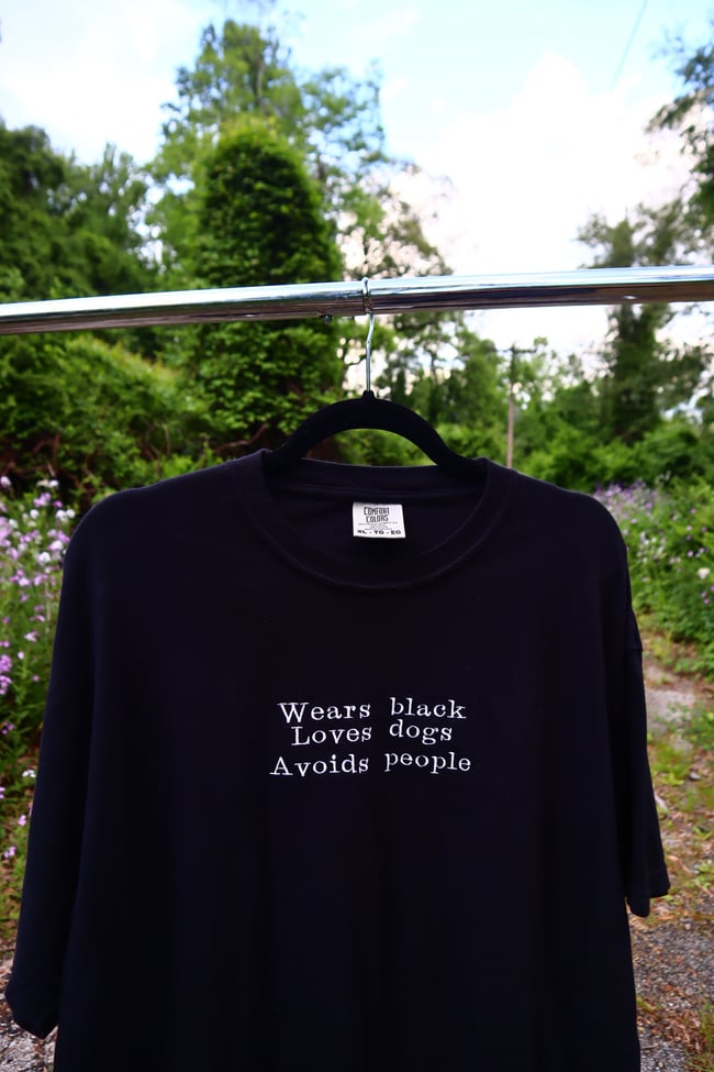 WEARS BLACK LOVES DOGS AVOIDS PEOPLE