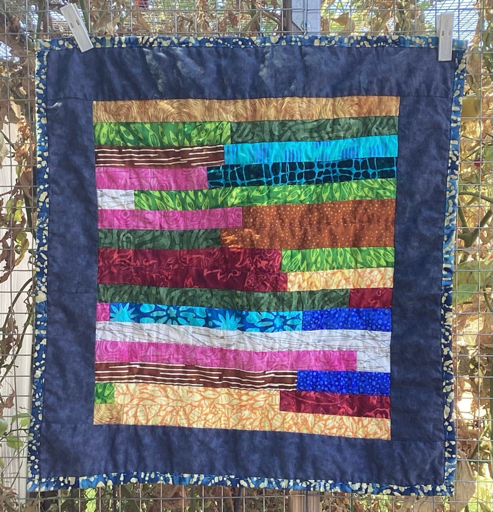 Image of Scrappy Batik Strip Cat Quilt