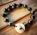 Image of Hand Knotted Tahitian pearl bracelet with puka shell clasp