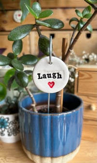 Image 1 of Ceramic Motivational Words with a Heart Motif Tag on a wire stake 