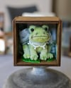 Pipe cleaner miniature frog with its magnetic wooden display 