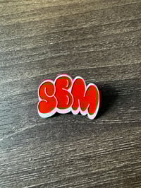 SBM orange and white pin