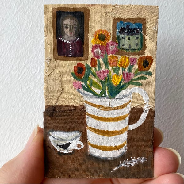 Image of still life with summer flowers in a striped jug and paintings