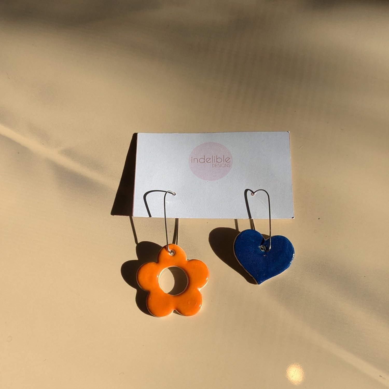 Image of orange daisy and blue heart asymmetrical earrings