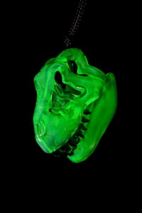 Image 4 of Fully uv reactive green slyme mini T-Rex skull pendant. 💚