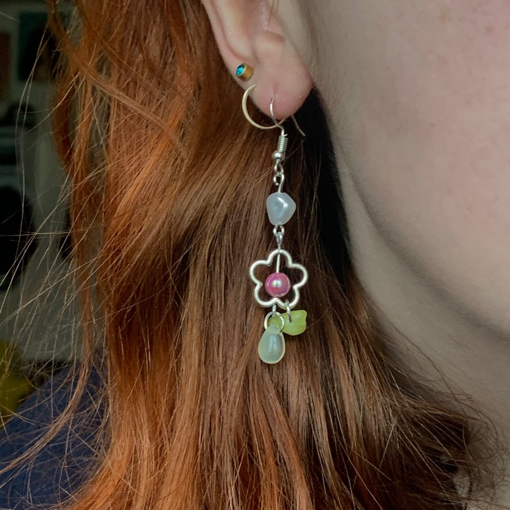 Image of tooth and flower charm earrings