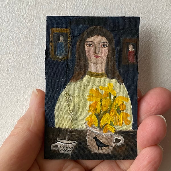 Image of woman at a table with daffodils - tiny painting 