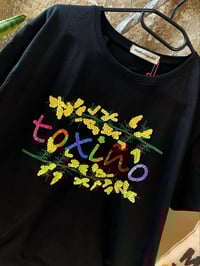 Camiseta bordada a man. Toxiño negra/cores. Con flores. Varias tallas . Corte unisex.