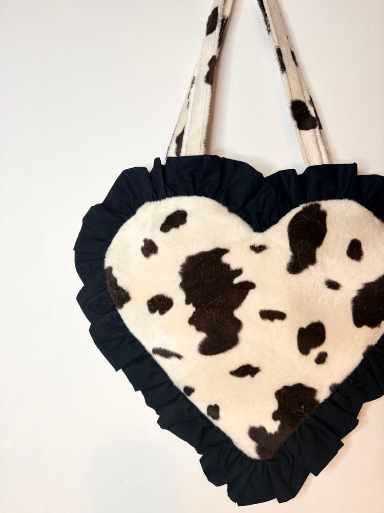 Image of Heart-Shaped Cream & Brown Cow Print Fur Bag with Black Ruffle Trim