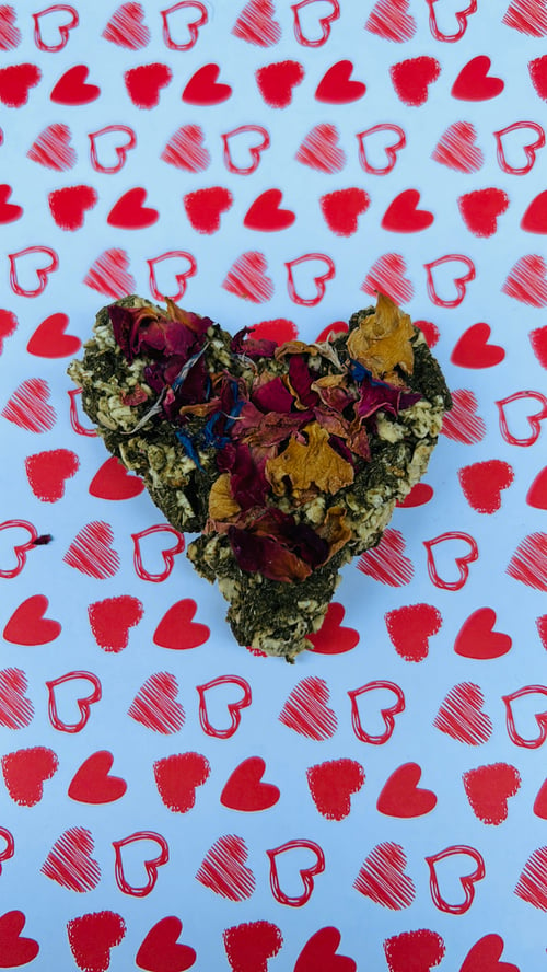 Image of Heart shaped healthy munchy treat bite with rose petals