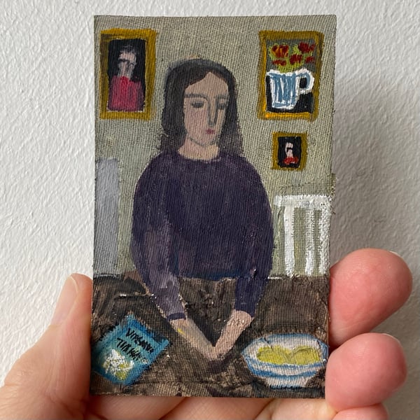 Image of woman in purple at a table with book