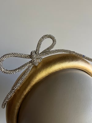 Image of Gold padded headband w diamanté bow. 
