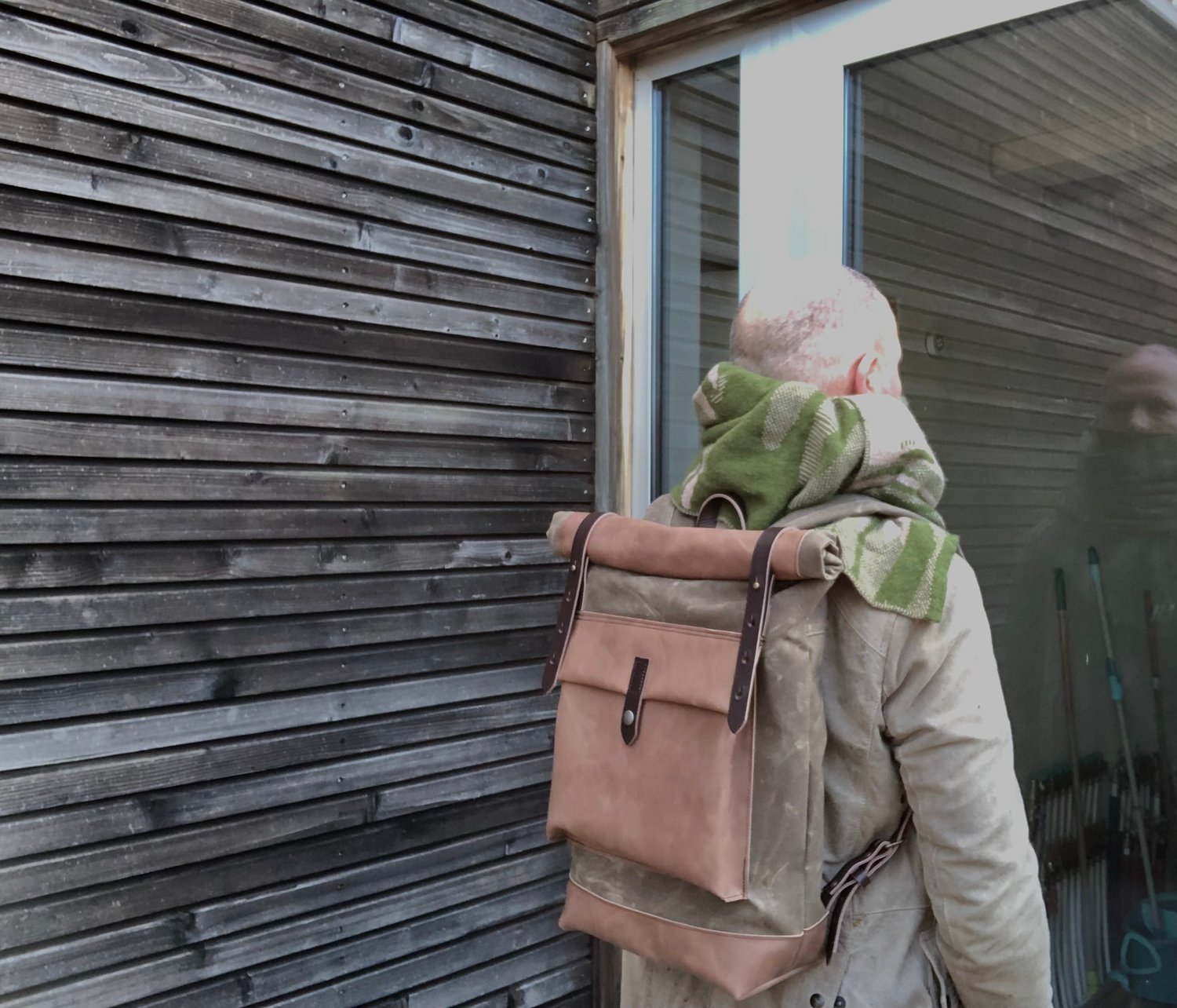 Waxed canvas backpack with roll to close top with leather bottom and  outside pocket in dark taupe