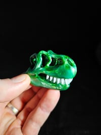 Image 1 of Chromium T-Rex skull pendant with glowin glass glow in the dark teeth.