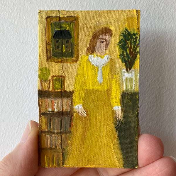 Image of woman in yellow with bookish interior
