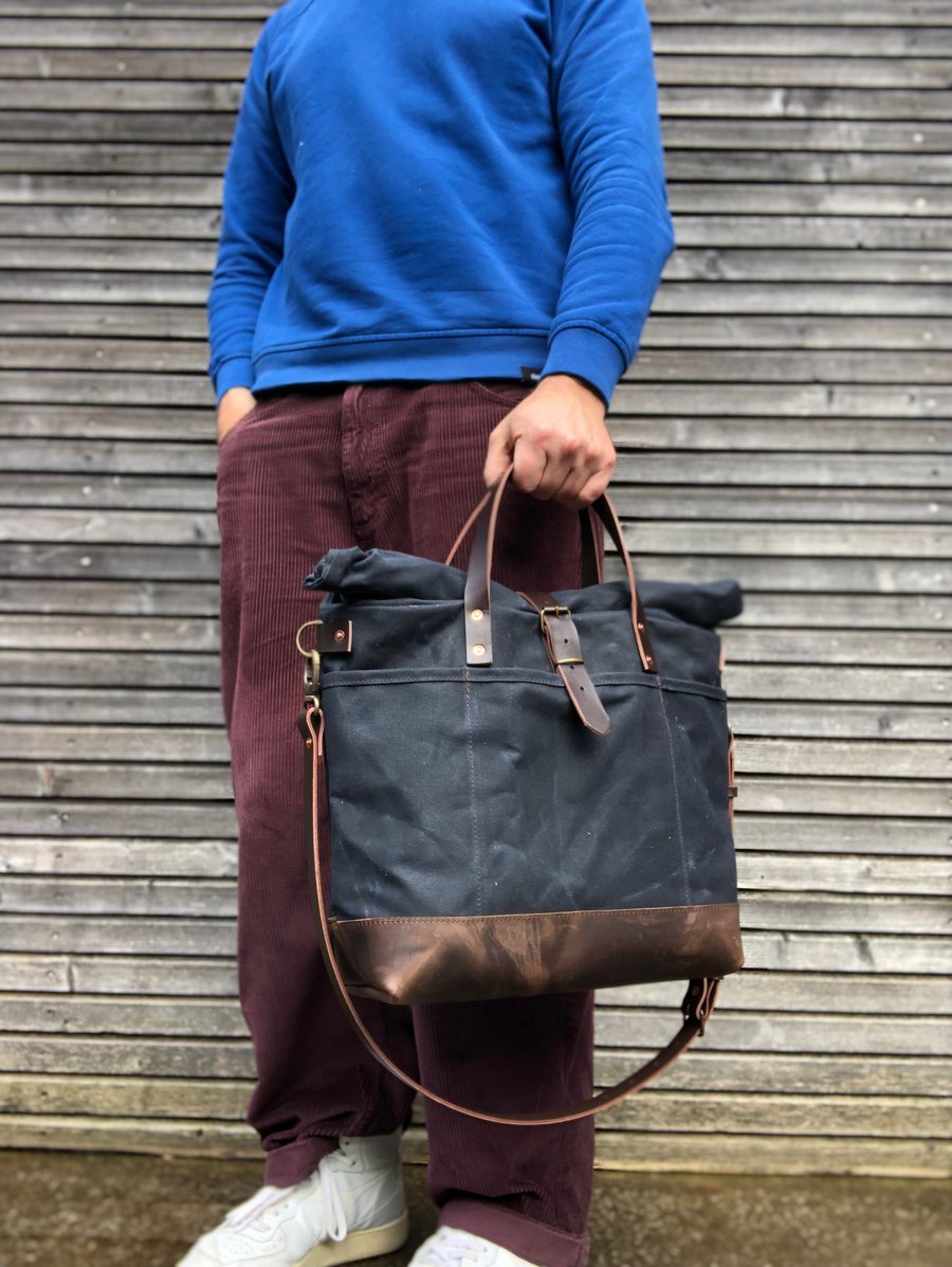 Image of Black waxed canvas roll to close top tote bag with luggage handle attachment 