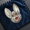 Blue velvet bat patch cushion cover with black pom pom fringing