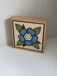 Framed blue flower on canvas