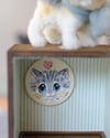 Pipe cleaner miniature tabby cat with its magnetic wooden display