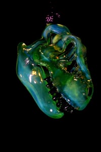 Image 1 of Fully uv reactive green slyme mini T-Rex skull pendant. 💚