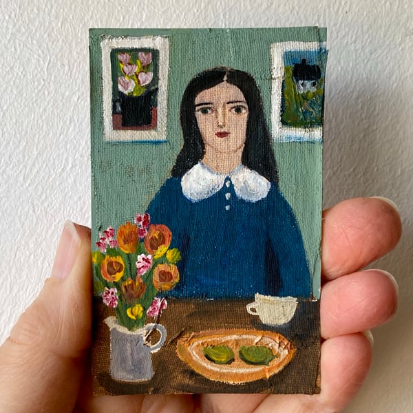 Image of woman in blue at a table with summer flowers 