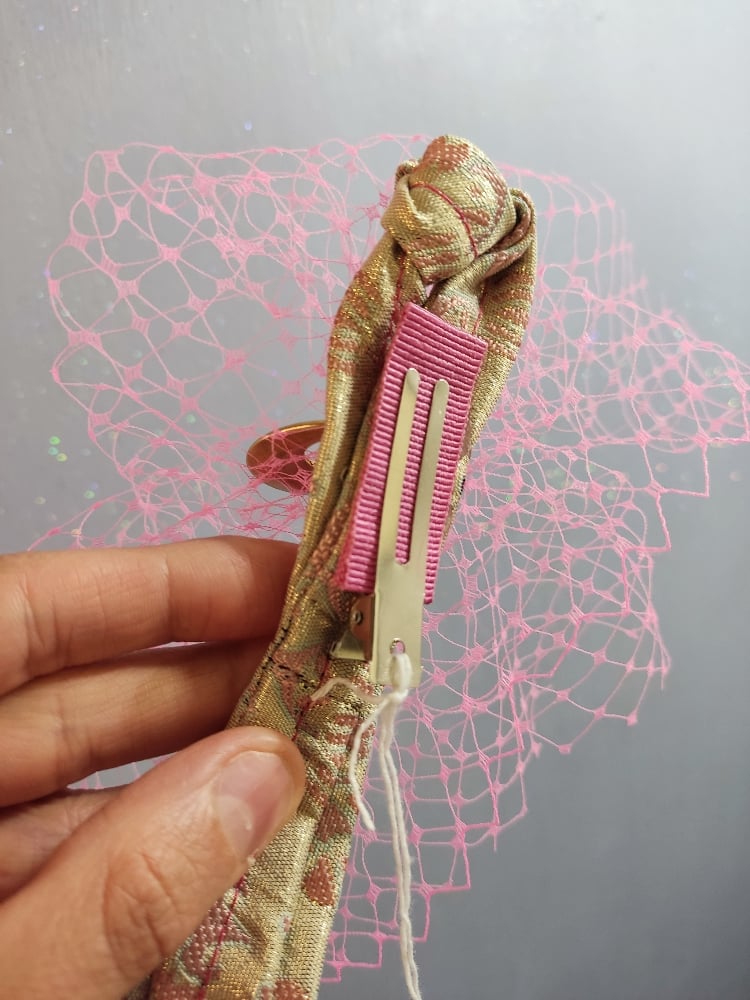 Image of Fermaglio con veletta rosa e code