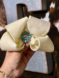Ivory ribbon bow with teal concho 