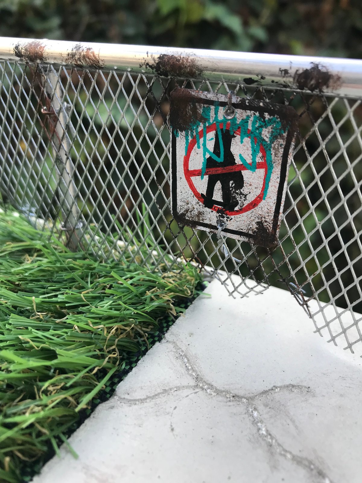 Sidewalk with grass gap center and chain link fence