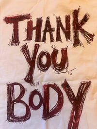 Image 1 of White tshirt with burgundy and flecked orange text (small)