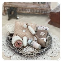 Image 2 of Vintage style tattered square pin cushion sitting on a tray full of sewing notions